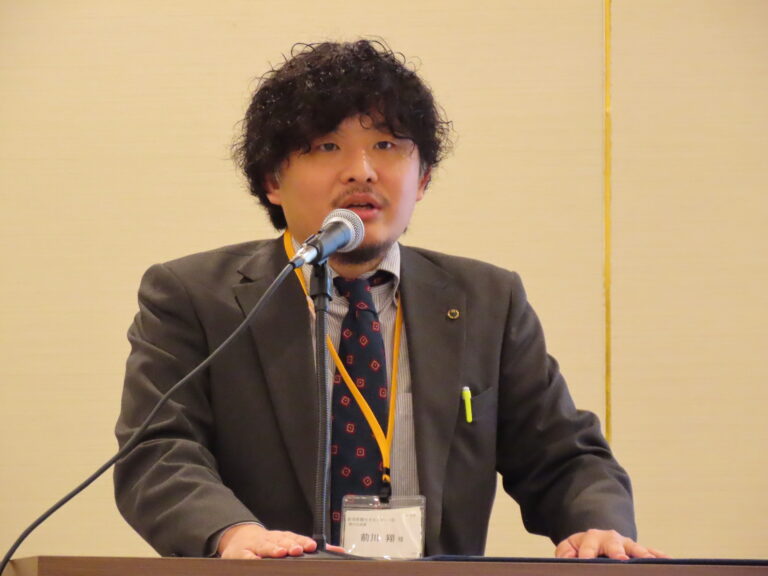 新潟県の花角英世知事のあいさつを代読する新潟県観光文化スポーツ部の前川翔副部長