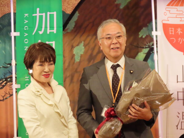 第2次石破内閣で財務副大臣に就任した横山信一参議院議員には花束を贈呈